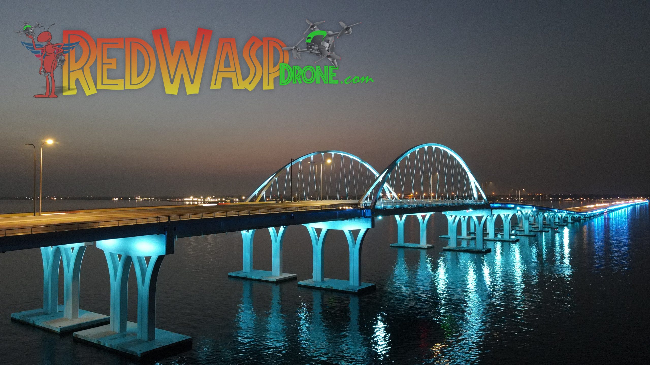 Pensacola bridge lights, night photography, stunning architecture, aerial view, Gulf Breeze-Pensacola region, mesmerizing spectacle, vibrant illumination, architectural masterpiece, captivating beauty, Red Wasp Drone,